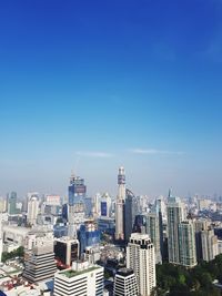 Modern buildings in city against blue sky