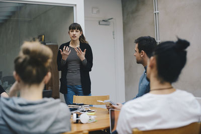 Female computer programmer giving presentation to colleagues in office