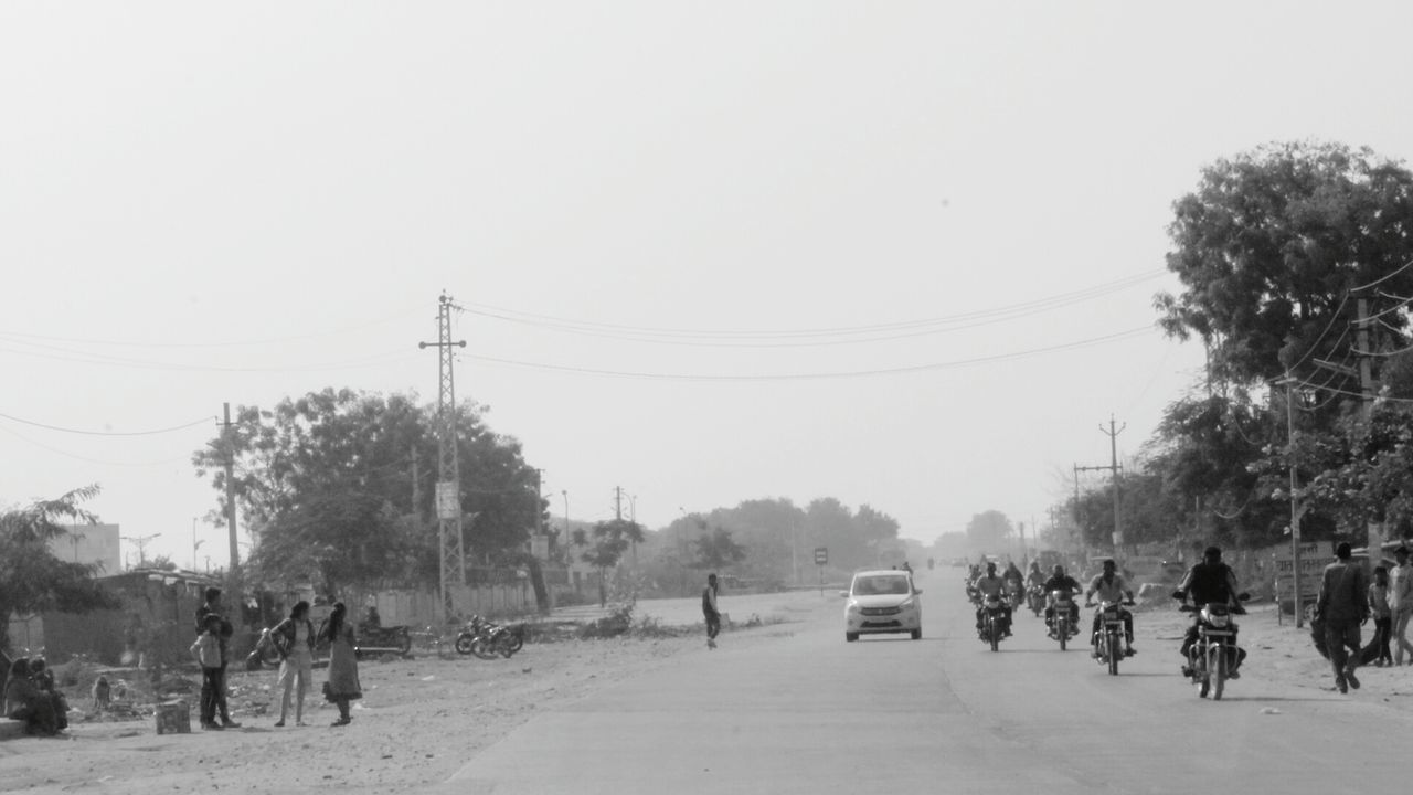 PEOPLE ON ROAD AGAINST SKY