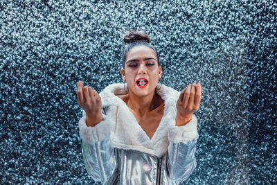 Woman with ice in mouth against defocused background