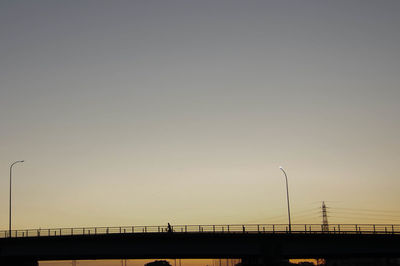 Silhouette bridge against clear sky during sunset
