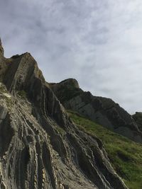 Low angle view of rocks on mountain against sky