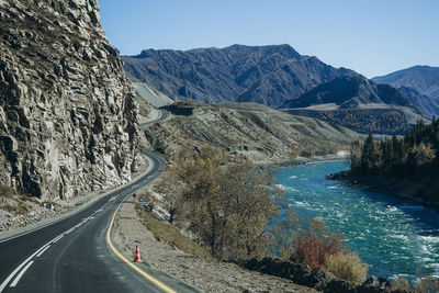 Road leading towards mountains against sky