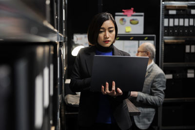 Portrait of woman using laptop at office