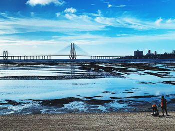 Bridge over river against sky during winter