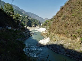 Scenic view of river amidst mountains against clear sky