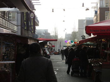 Rear view of people walking on street in city