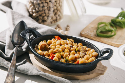 Chickpea stew with ingredients in background on table