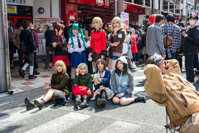 Group of people sitting on street in city