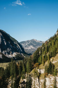 Scenic view of mountains against blue sky during sunny day