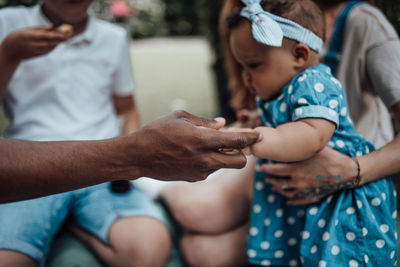 Midsection of mother and daughter on hands