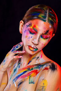 Portrait of woman with multi colored hair against black background