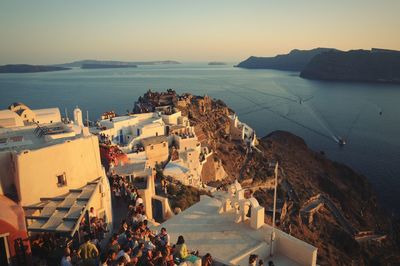 High angle view of people amidst buildings at santorini during sunset