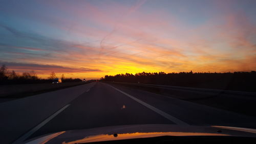 Car on road against sky during sunset