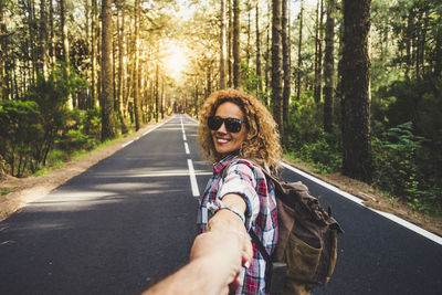 Portrait of woman riding motorcycle on road in forest