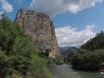 Scenic view of river flowing towards mountains against sky