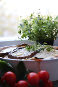 Close-up of food served in container with tomatoes on table