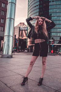 Full length of woman standing in city at dusk