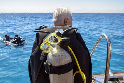 Scuba diver before diving. male in scuba diving suit is preparing to dive into deep sea.