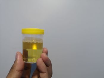 Midsection of person holding drink against white background