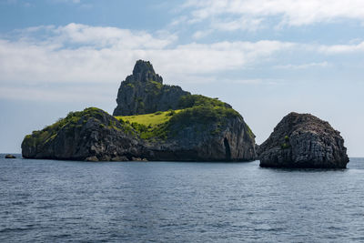 Rock formation by sea against sky