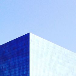 Low angle view of office building against blue sky