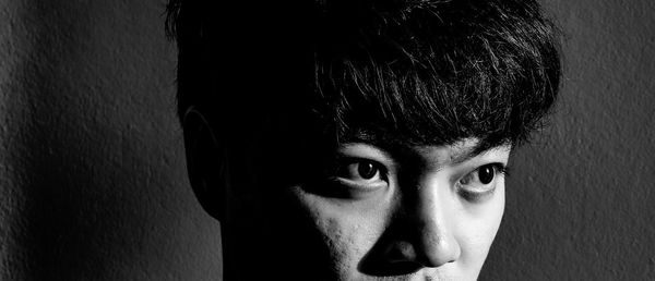 Close-up portrait of young man against wall