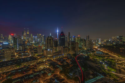 Illuminated cityscape against sky at night