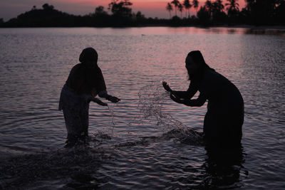 Two women splashing water on the beach