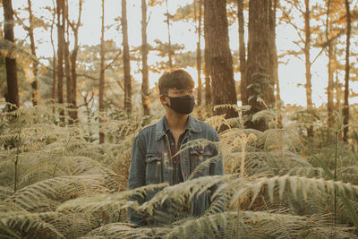 Young man on field in forest