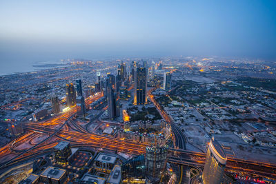 Illuminated cityscape against clear sky at dusk