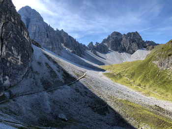 Scenic view of road by mountains against sky