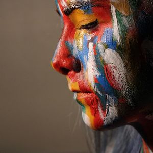 Close-up of human hand against multi colored background