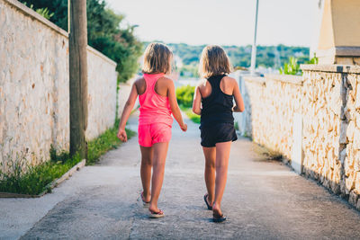 Rear view of women walking on footpath