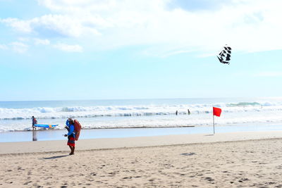 People on beach against sky