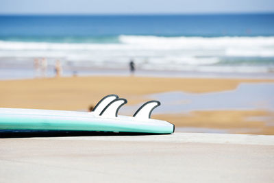 The blue of the sea with a surfboard in the foreground on the sandy beach. relaxing outdoor 