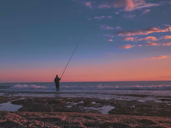 Natural view of the sea against the sky at sunset, a man fishing with a fishing rod