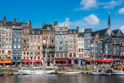 Buildings in city against cloudy sky
