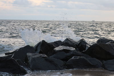 Rocks in sea against sky