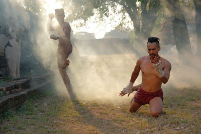 Full length of shirtless man standing on land