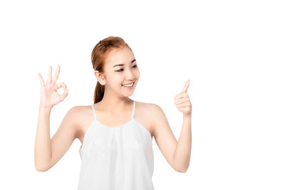 Portrait of smiling young woman against white background