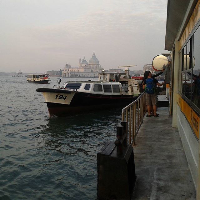 architecture, built structure, water, building exterior, men, nautical vessel, transportation, lifestyles, sky, mode of transport, leisure activity, travel, rear view, railing, river, sea, person, full length