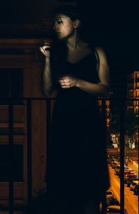 Young woman holding camera at night