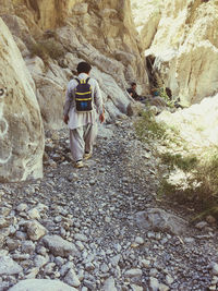 Rear view of man walking on rock