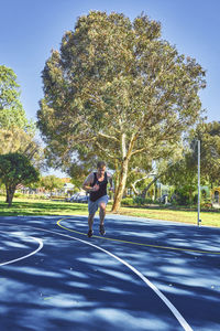 Young man running on road while exercising at park