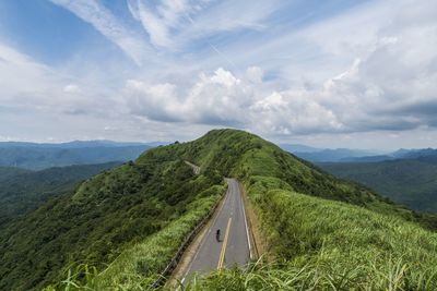 Panoramic view of road leading towards mountains against sky