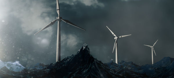 Low angle view of windmills against sky