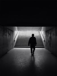 Rear view of woman walking in tunnel