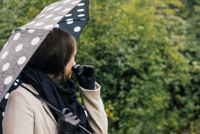 Midsection of woman holding umbrella