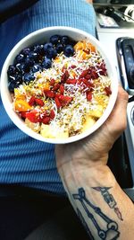 Close-up of hand holding bowl of food